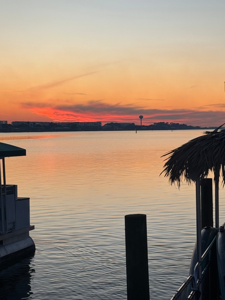 Dockside tiki hut overlooking fiery red-orange sunset